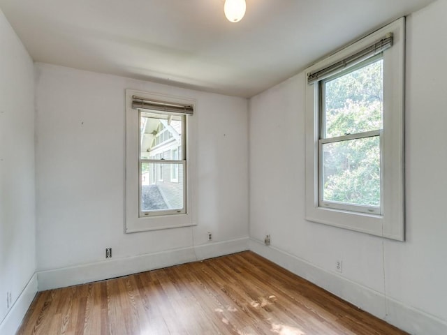 unfurnished room with baseboards and wood finished floors