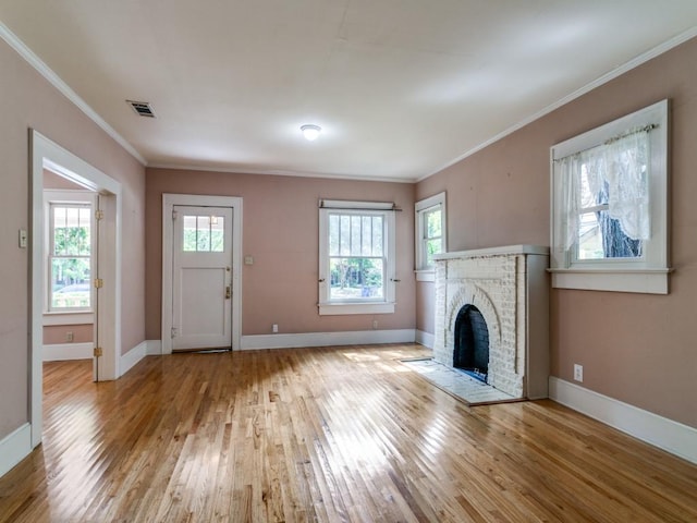 unfurnished living room featuring baseboards, a fireplace, crown molding, and hardwood / wood-style flooring