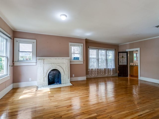 unfurnished living room with light wood finished floors, baseboards, and ornamental molding