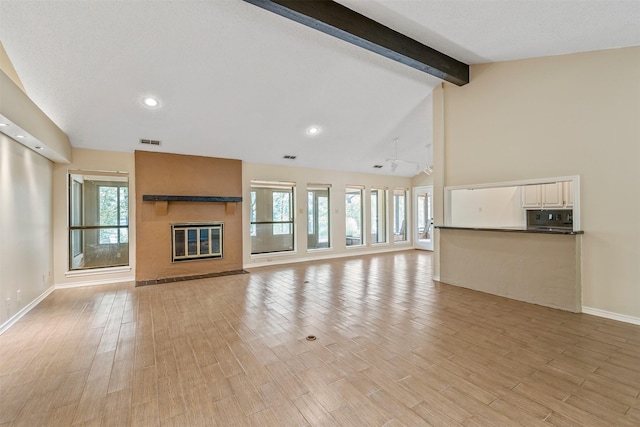 unfurnished living room featuring baseboards, a large fireplace, recessed lighting, visible vents, and beamed ceiling