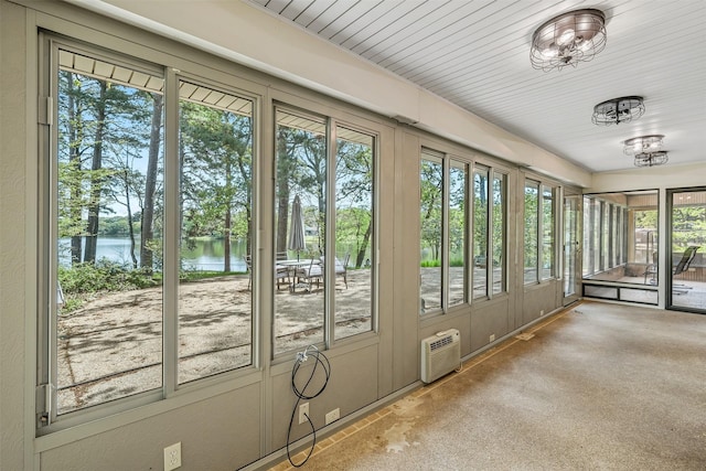 unfurnished sunroom with a water view and a wall mounted AC
