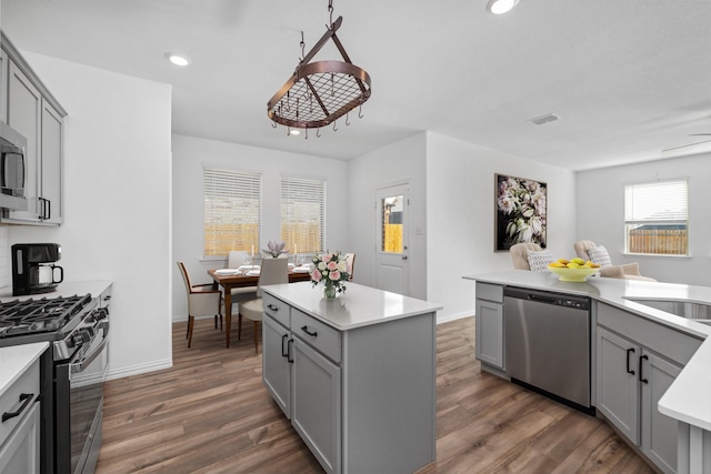 14828 Devils Claw Trl, Fort Worth, TX 76052 - kitchen with stainless steel appliances, gray cabinets, a kitchen island, dark wood-style floors, and recessed lighting
