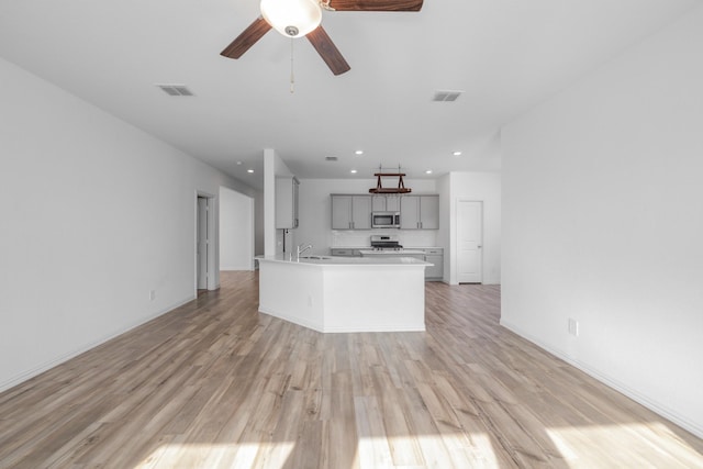 14828 Devils Claw Trl, Fort Worth, TX 76052 - kitchen with stainless steel appliances, light wood-style floors, light countertops, gray cabinets, and recessed lighting