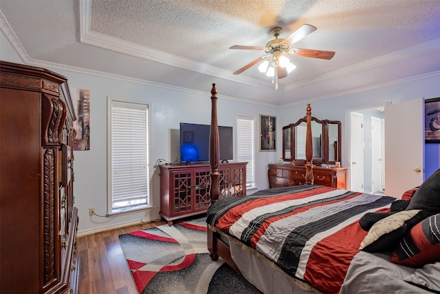 1511 Dolly Ln, Hideaway, TX 75771 - bedroom featuring a textured ceiling, wood finished floors, a tray ceiling, ornamental molding, and ceiling fan