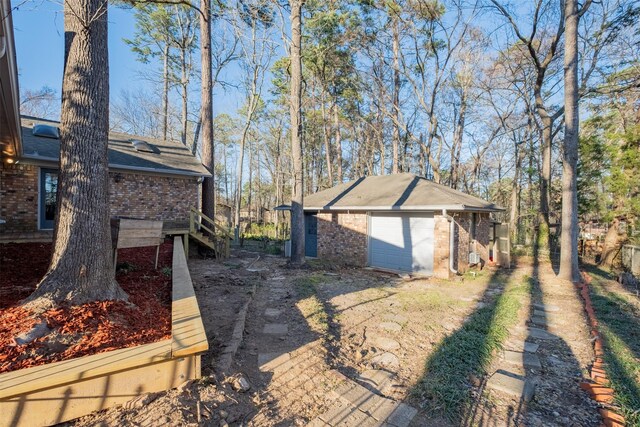 1511 Dolly Ln, Hideaway, TX 75771 - view of home's exterior featuring brick siding, an outdoor structure, a garage, and a shingled roof