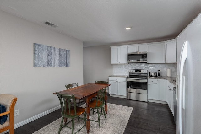 6827 Briar Rd, Azle, TX 76020 - kitchen with appliances with stainless steel finishes, tasteful backsplash, dark wood-type flooring, white cabinetry, and recessed lighting