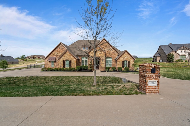 french country inspired facade with stone siding and a front yard