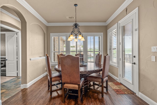 dining area featuring visible vents, ornamental molding, wood finished floors, and a notable chandelier