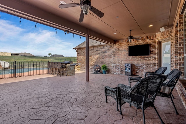 view of patio featuring a ceiling fan, outdoor dry bar, fence, and a fenced in pool