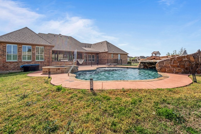 view of pool with fence, a fenced in pool, a lawn, a jacuzzi, and a patio area