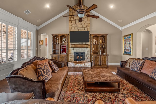 living room featuring a ceiling fan, a fireplace, wood finished floors, visible vents, and arched walkways