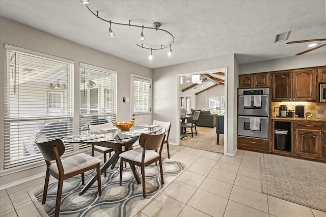dining area with light tile patterned floors, visible vents, baseboards, and a textured ceiling