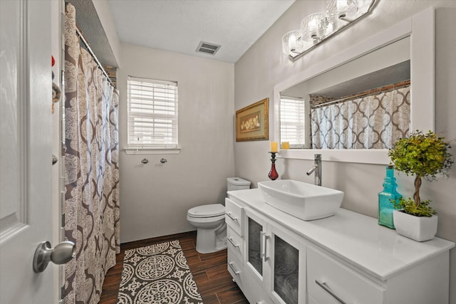 full bathroom featuring visible vents, toilet, plenty of natural light, and wood finished floors