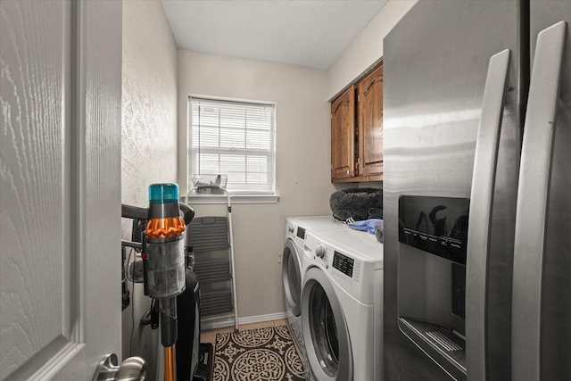 laundry room featuring cabinet space, light tile patterned floors, baseboards, and washer and dryer