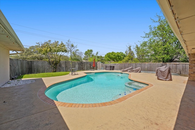 view of pool featuring a patio area, a fenced backyard, and a pool with connected hot tub
