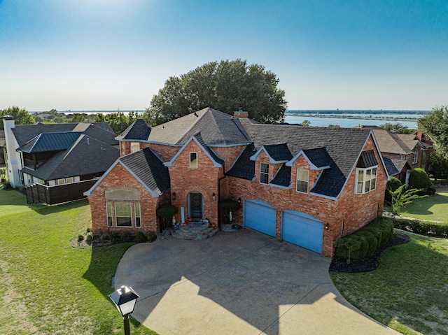 101 Reliance Ct, Rockwall, TX 75032 - view of front facade with a garage, brick siding, a water view, and a front lawn
