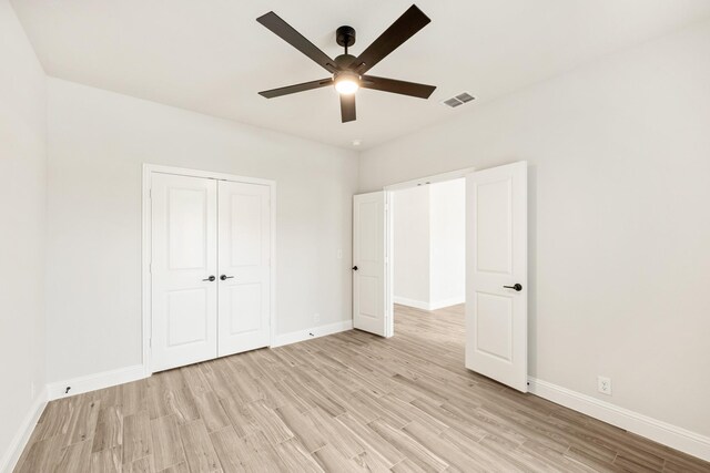 unfurnished bedroom featuring light wood-style floors, baseboards, a closet, and ceiling fan