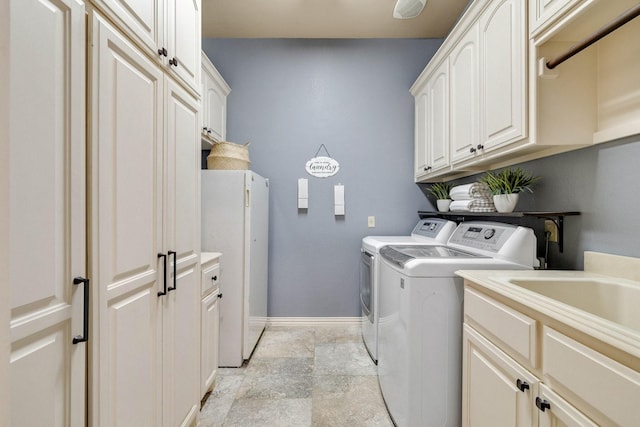 1121 Crystal Falls Dr, Prosper, TX 75078 - washroom featuring washer and clothes dryer, cabinet space, light stone finish floors, and baseboards