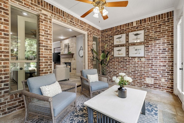 1121 Crystal Falls Dr, Prosper, TX 75078 - living area featuring brick wall, ceiling fan, crown molding, and a large fireplace
