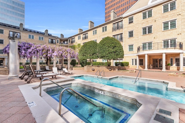 pool featuring a hot tub and a patio