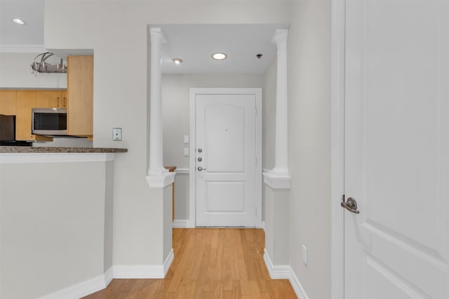 hallway with baseboards, ornate columns, recessed lighting, and light wood-type flooring
