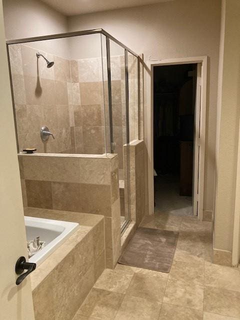bathroom with a bath and a stall shower