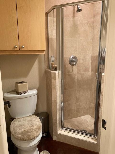 full bath with toilet and a stall shower