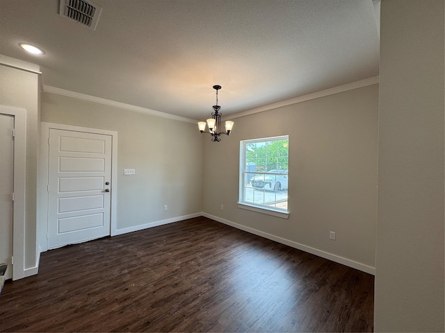 spare room featuring crown molding, visible vents, an inviting chandelier, baseboards, and dark wood-type flooring