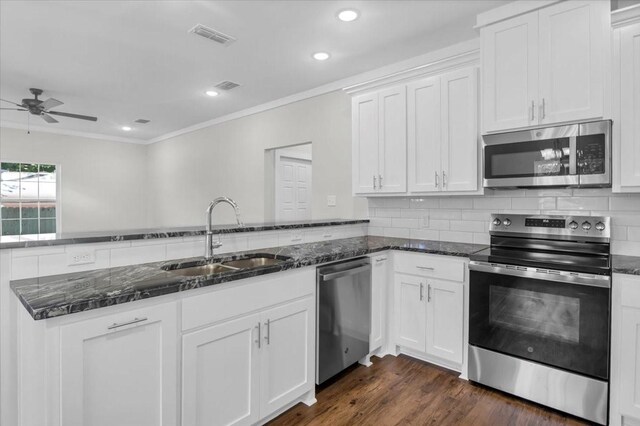2377 Ridgley Dr, Flint, TX 75762 - kitchen with stainless steel appliances, a sink, ornamental molding, ceiling fan, and dark stone counters