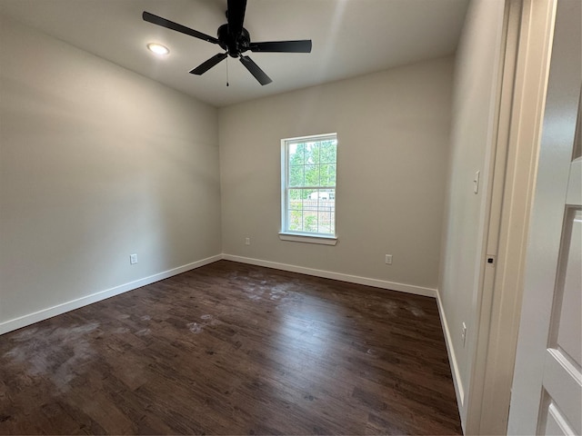 unfurnished room featuring baseboards, dark wood finished floors, and ceiling fan