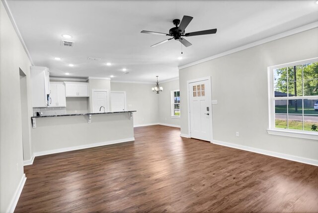 2377 Ridgley Dr, Flint, TX 75762 - unfurnished living room featuring ornamental molding, a chandelier, healthy amount of natural light, dark wood finished floors, and ceiling fan