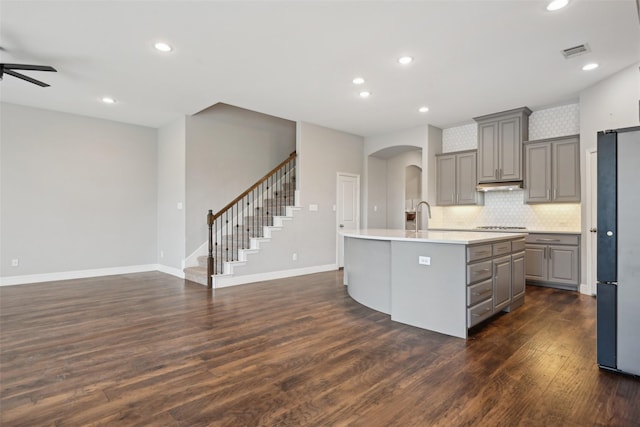 1909 Old Charm Trl, Wylie, TX 75098 - kitchen with freestanding refrigerator, visible vents, arched walkways, light countertops, and gray cabinets