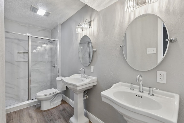 3931 Roma Ct, Rockwall, TX 75087 - full bathroom with a textured ceiling, a shower stall, toilet, wood finished floors, and a sink