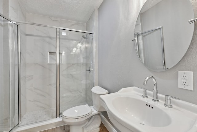 3931 Roma Ct, Rockwall, TX 75087 - full bathroom with a sink, a textured ceiling, toilet, a marble finish shower, and a textured wall