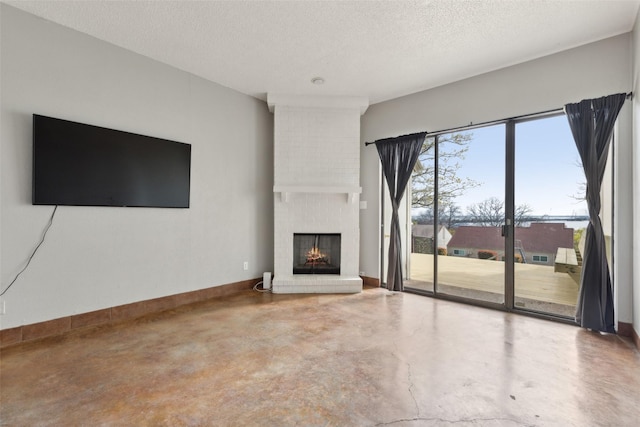 3931 Roma Ct, Rockwall, TX 75087 - unfurnished living room featuring finished concrete flooring, a fireplace, a textured ceiling, and baseboards