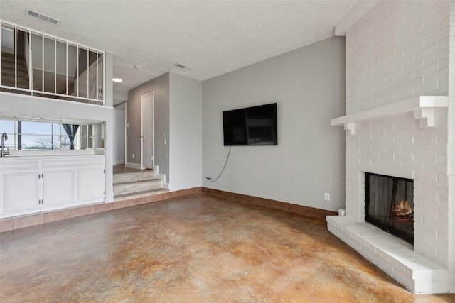 3931 Roma Ct, Rockwall, TX 75087 - unfurnished living room featuring finished concrete flooring, a fireplace, baseboards, and a textured ceiling