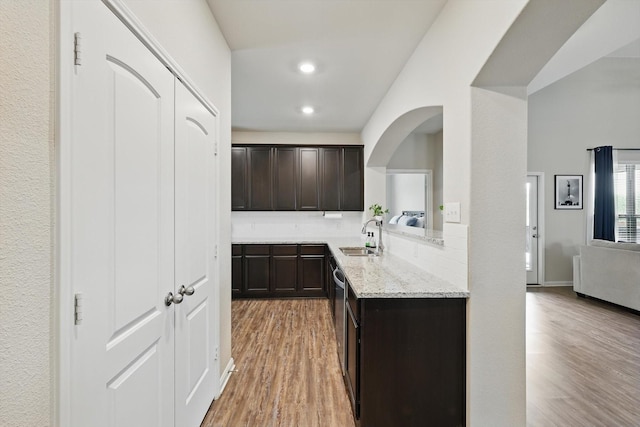 1616 Mackinac Dr, Crowley, TX 76036 - kitchen with a sink, dark brown cabinetry, light stone countertops, backsplash, and light wood-style floors