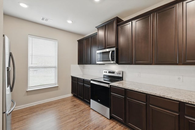 1616 Mackinac Dr, Crowley, TX 76036 - kitchen featuring visible vents, backsplash, baseboards, dark brown cabinets, and appliances with stainless steel finishes