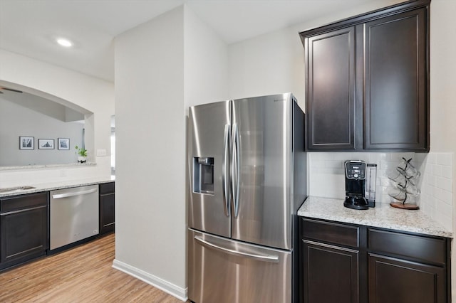 1616 Mackinac Dr, Crowley, TX 76036 - kitchen featuring light stone countertops, light wood-style flooring, dark brown cabinets, stainless steel appliances, and tasteful backsplash