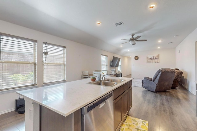 kitchen with stainless steel dishwasher, open floor plan, light wood finished floors, and a sink