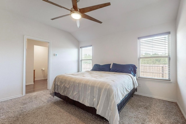 carpeted bedroom featuring baseboards, lofted ceiling, and ceiling fan