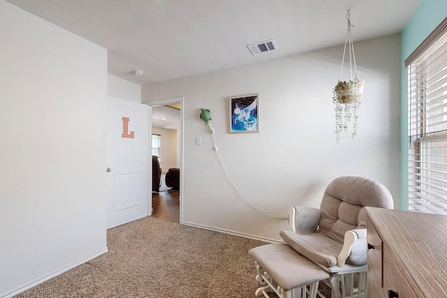 sitting room with baseboards, visible vents, and carpet