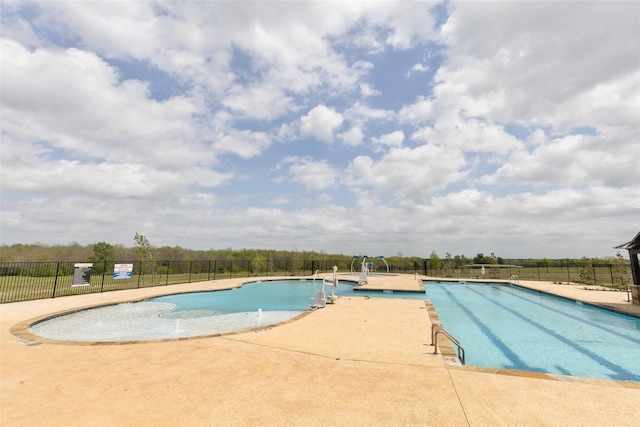 pool with a patio and fence