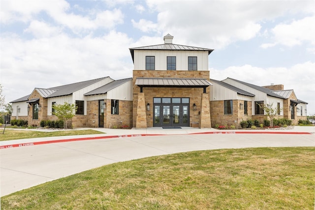 modern inspired farmhouse with metal roof, a standing seam roof, and french doors