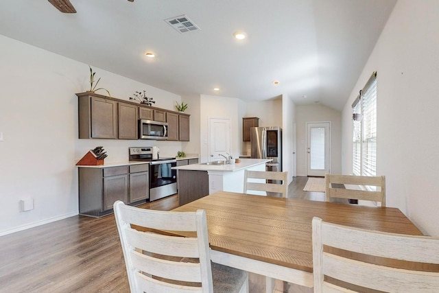 dining room featuring lofted ceiling, light wood-style flooring, baseboards, visible vents, and recessed lighting