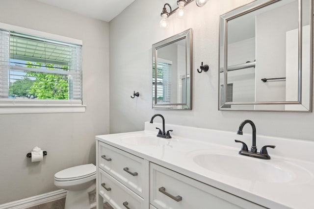 full bathroom featuring healthy amount of natural light, toilet, and double vanity