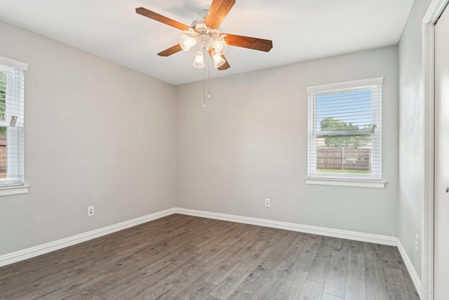 unfurnished room with wood finished floors, healthy amount of natural light, baseboards, and ceiling fan