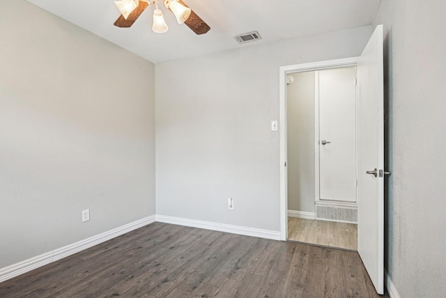 unfurnished room featuring wood finished floors, a ceiling fan, and baseboards
