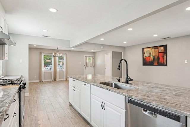 kitchen with stainless steel appliances, a sink, recessed lighting, wall chimney exhaust hood, and white cabinets