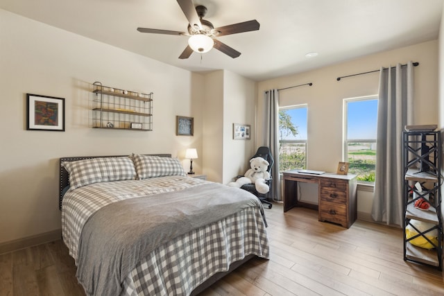 bedroom featuring ceiling fan, baseboards, and wood finished floors